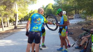 Mecánicos en ruta arreglando pinchazo de bicicleta de Toñi en sierra Muela Albudeite por Comunidad Biker MTB